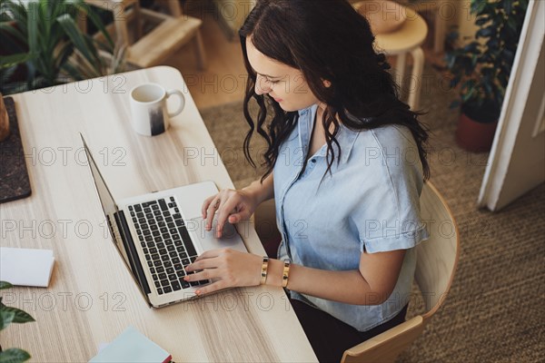 Caucasian woman using laptop at desk