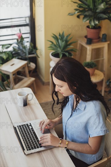 Caucasian woman using laptop at desk
