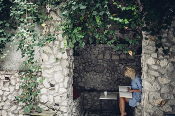 Woman sitting in stone patio