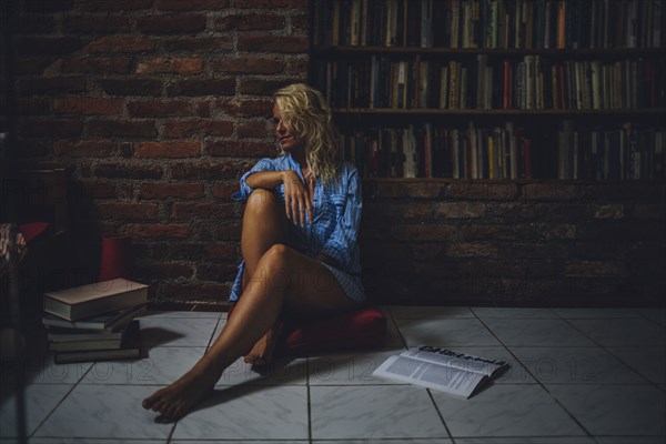 Smiling woman sitting on living room floor