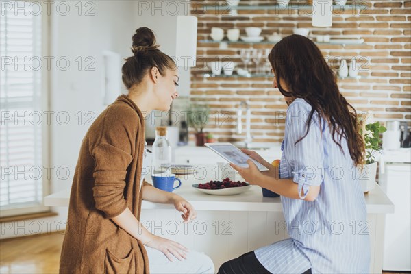 Caucasian women using digital tablet at counter