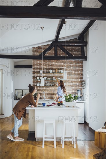 Caucasian women talking in kitchen