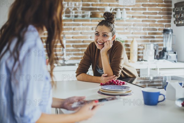 Caucasian women talking in kitchen