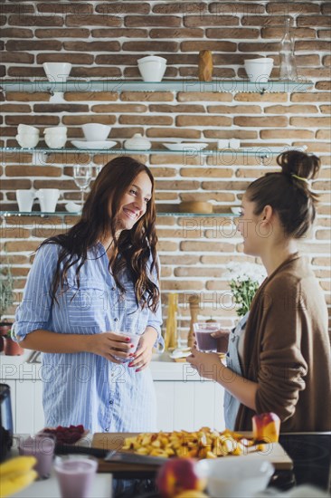 Caucasian women talking in kitchen