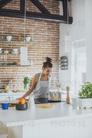 Caucasian woman cooking in kitchen