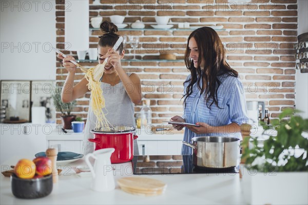 Caucasian women cooking pasta in kitchen