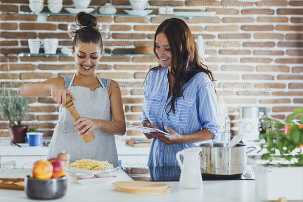 Caucasian women cooking pasta in kitchen