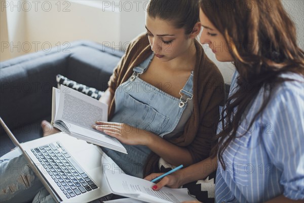 Caucasian women studying on sofa