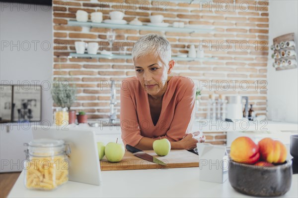 Older Caucasian woman cooking in kitchen