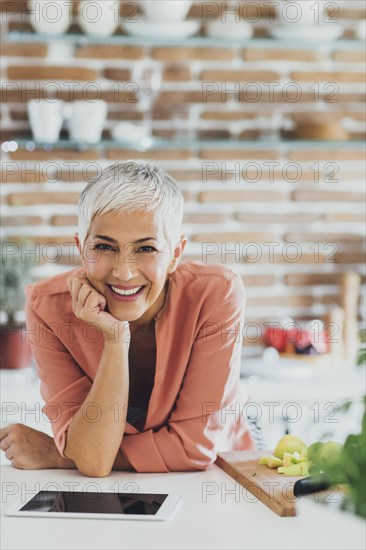 Older Caucasian woman smiling in kitchen