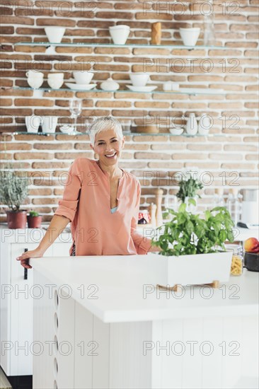 Older Caucasian woman smiling in kitchen