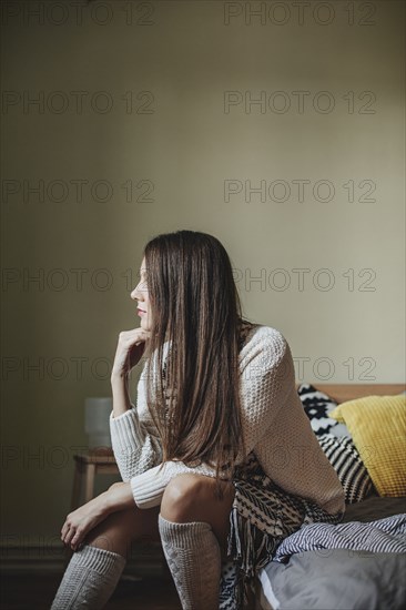 Caucasian woman sitting on bed