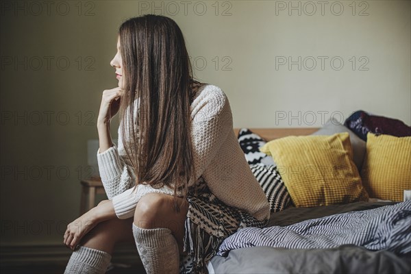 Caucasian woman sitting on bed