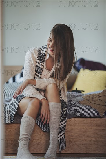 Caucasian woman sitting on bed