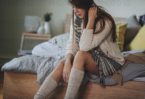 Caucasian woman sitting on bed