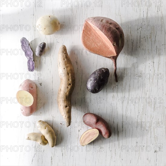 Variety of potatoes on white wooden table
