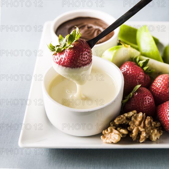 Strawberry dipping in white sauce