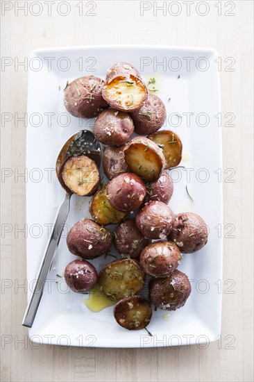 Spoon on plate of roasted potatoes
