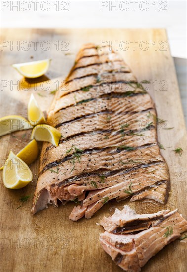 Salmon on cutting board with lemon wedges