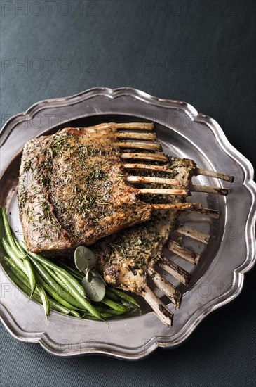 Rack of lamb and green beans on silver platter