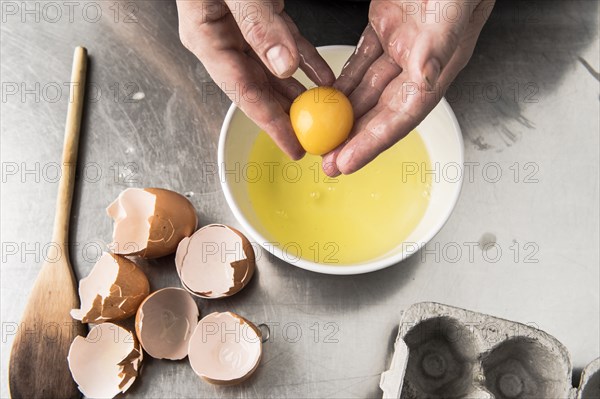 Hands holding egg yolk