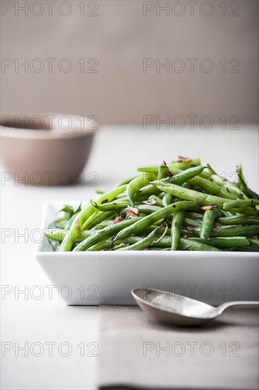 Pile of roasted green beans with spoon