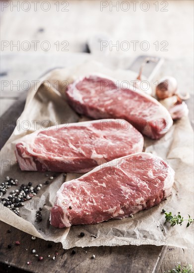 Raw steaks on butcher paper with pepper