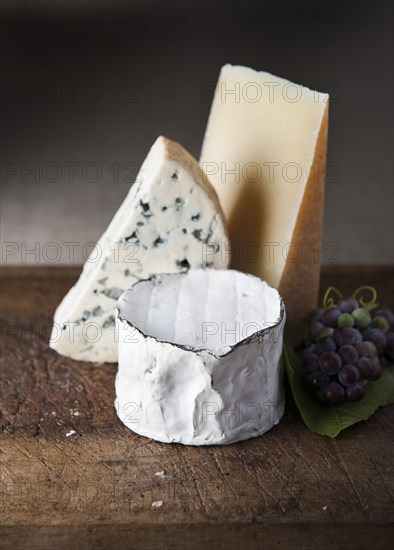 Artisanal cheese and grapes on wooden table