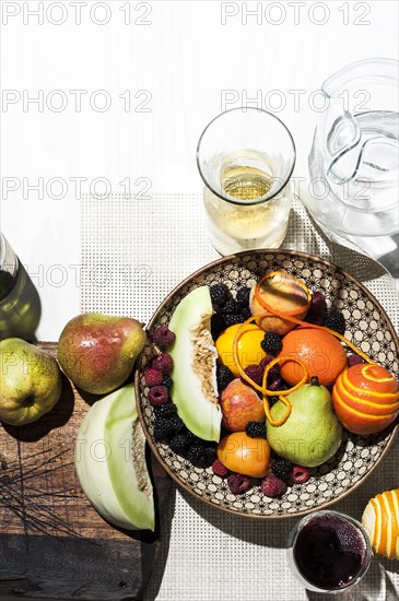 Bowl of fruit with wine and water
