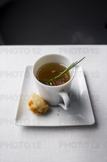 Spring of herb in cup of broth with bread
