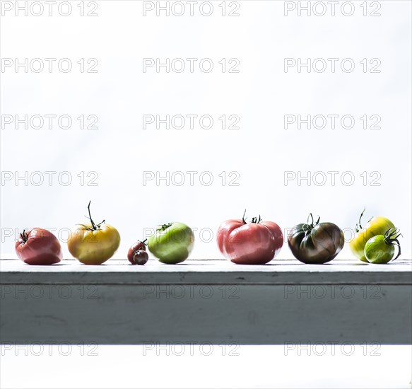 Row of fresh tomatoes on wooden table