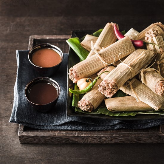 Tamales and dips on wooden tray