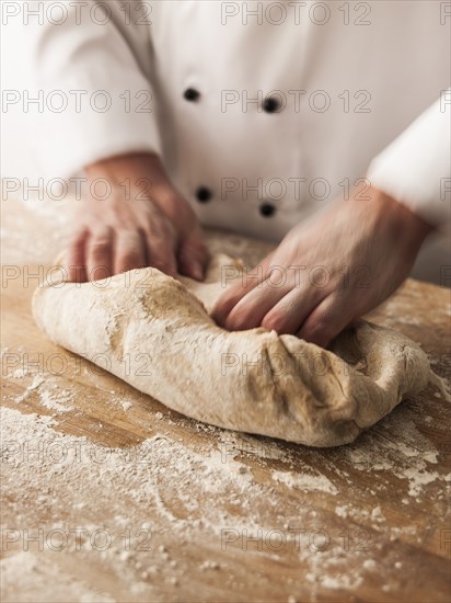 Hands of baker kneading dough