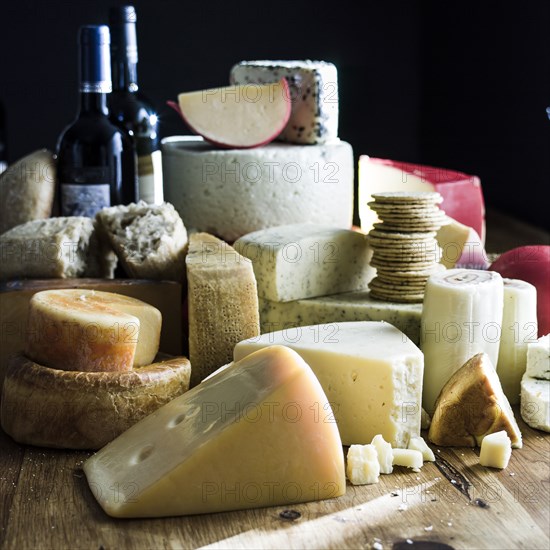 Assorted cheeses and bottles of wine