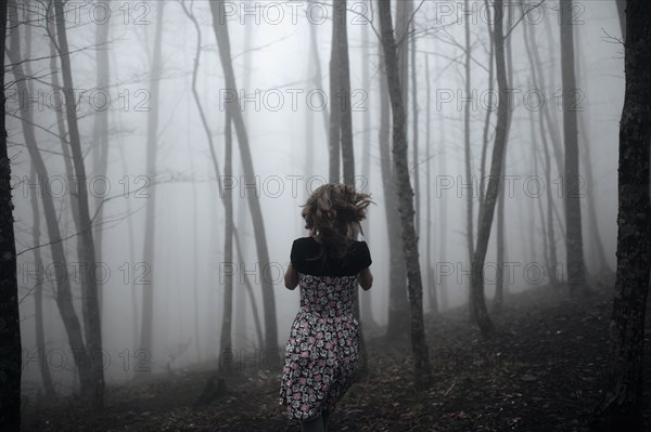 Caucasian woman running in forest