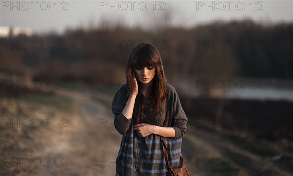 Caucasian woman standing on dirt road