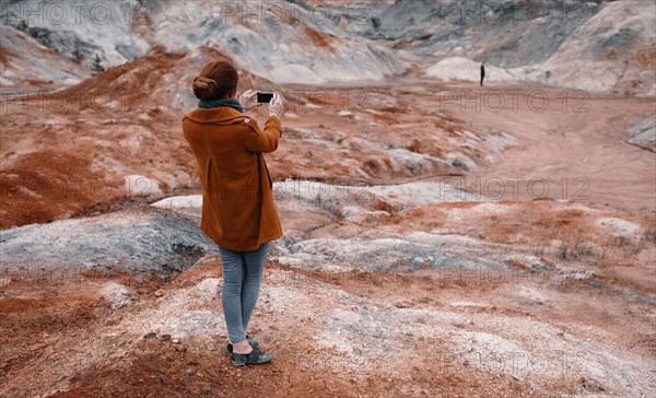 Caucasian woman photographing rock formations