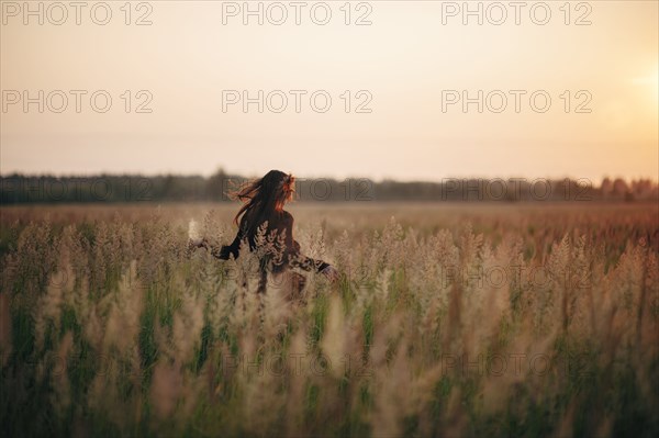 Caucasian woman walking in rural field