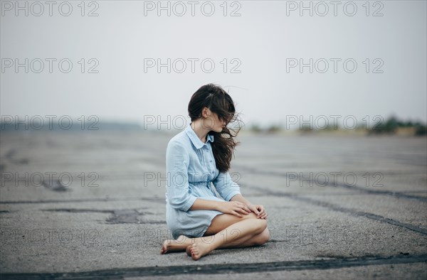 Caucasian woman sitting on concrete