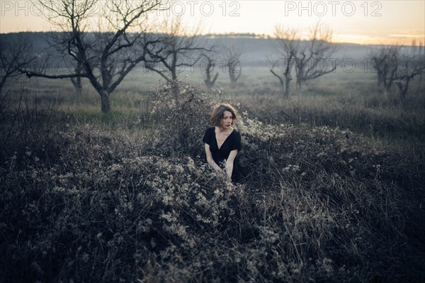 Caucasian woman sitting in remote field