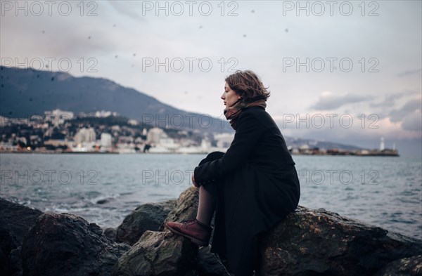 Caucasian woman admiring coastline from rock formation