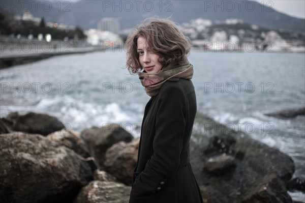 Caucasian woman standing on rock formation in harbor