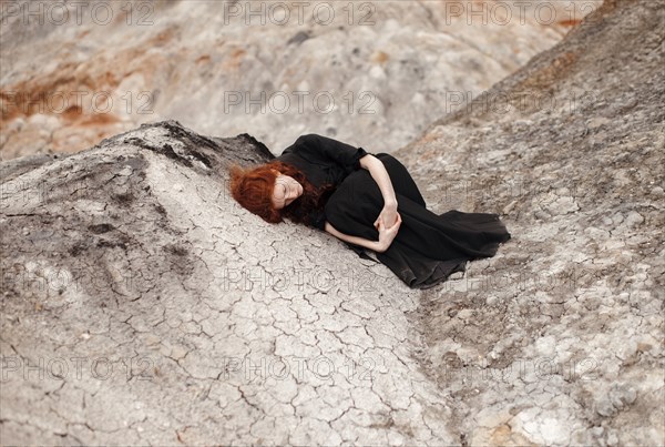 Caucasian woman laying on rock formation