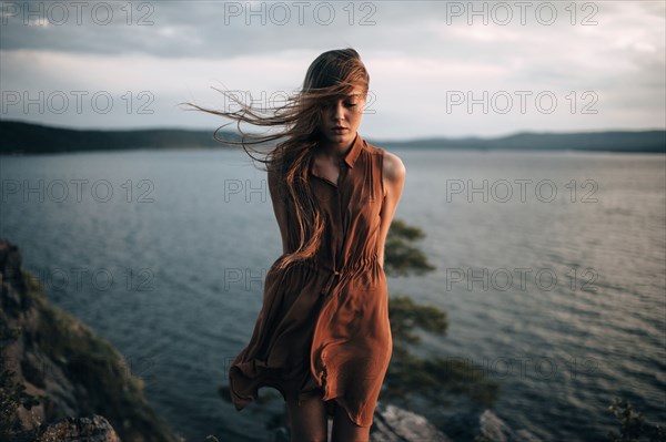 Caucasian woman standing near remote lake