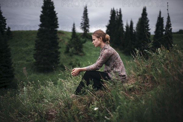 Caucasian woman sitting in remote field