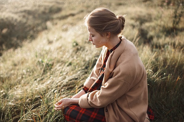 Caucasian woman sitting in remote field