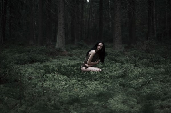 Caucasian woman sitting in forest