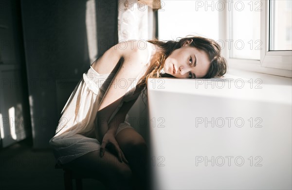 Caucasian woman leaning on windowsill