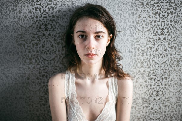 Caucasian woman standing at wallpaper