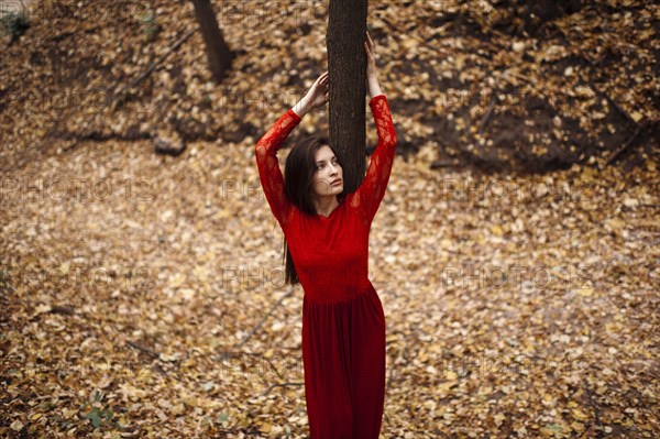 Caucasian woman standing in autumn leaves